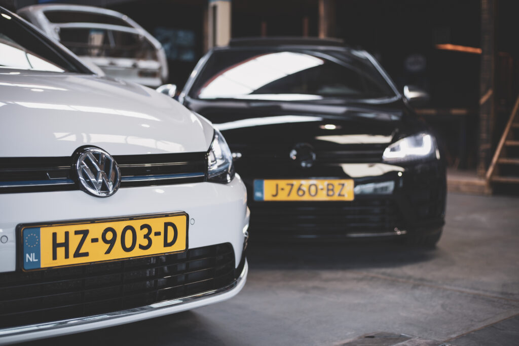 White and black Volkswagen cars in a workshop