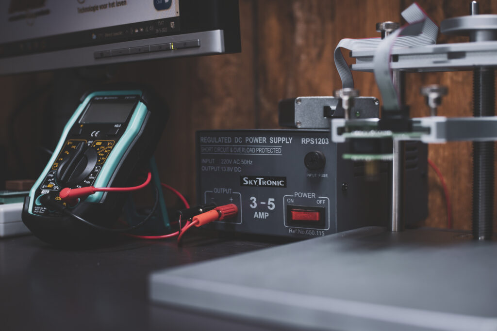 Multimeter, voeding en ECU-klem op een elektronicawerkbank